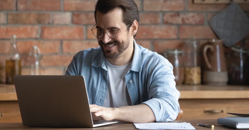 Smiling man in front of laptop.