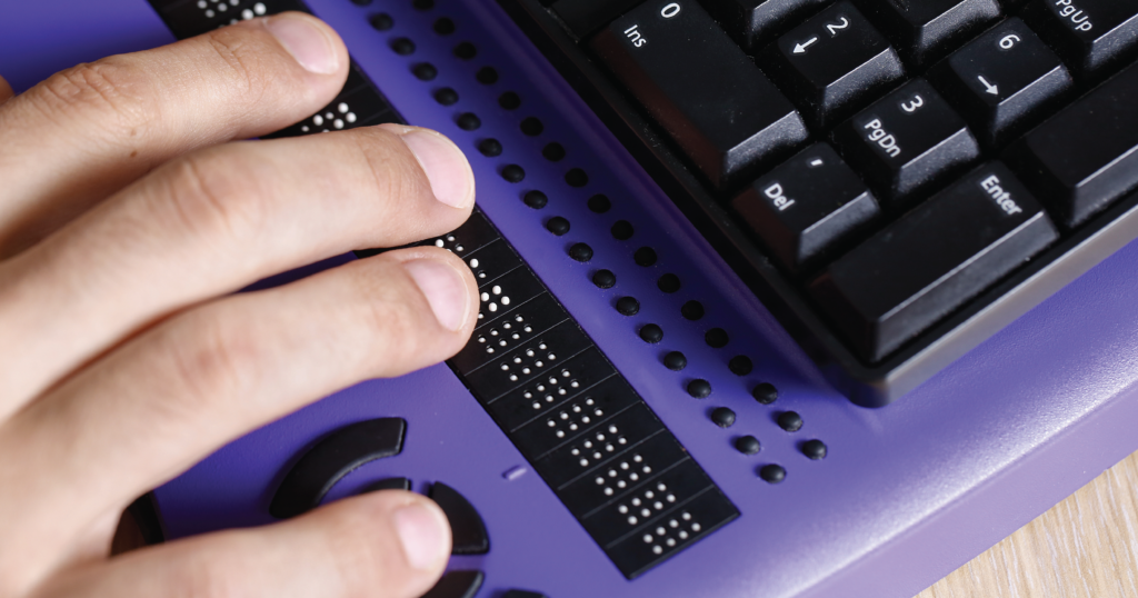 Right hand touching some braille on a computer keyboard